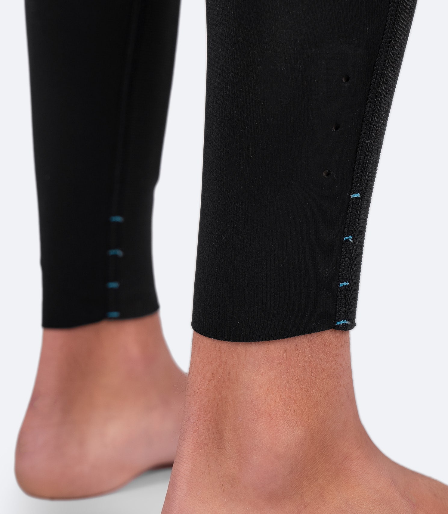 Close-up of Zhik Youth Microfleece Skiff Suit ankle area with drainage holes to expel trapped water and adjustable leg length for a custom fit