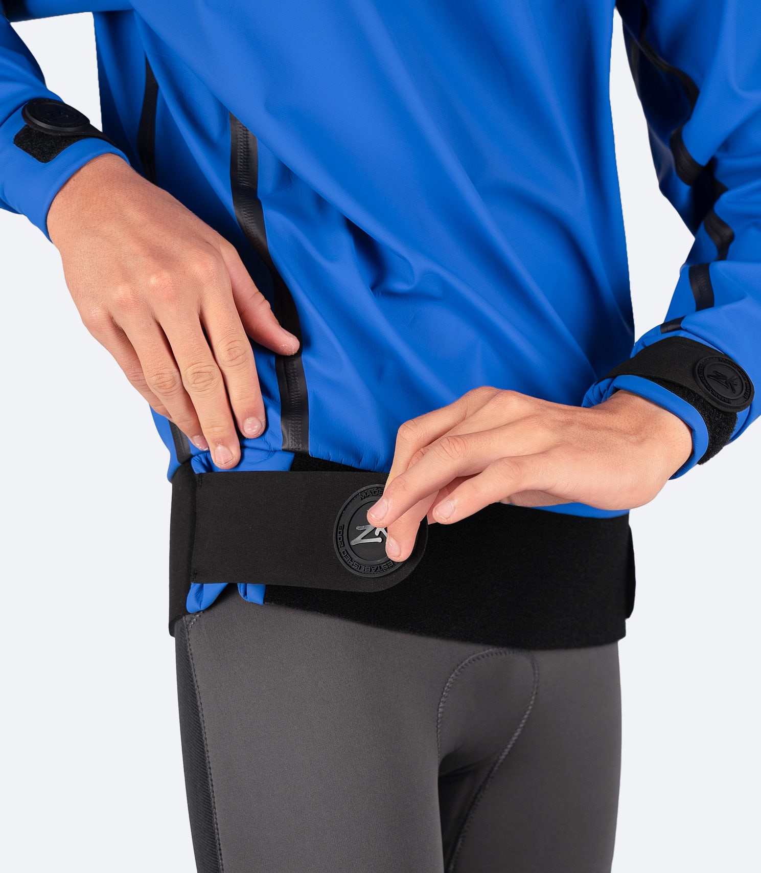 Close-up of Zhik Youth Shedding Smock in blue adjustable neoprene waistband, ensuring a secure, watertight seal for maximum comfort and protection