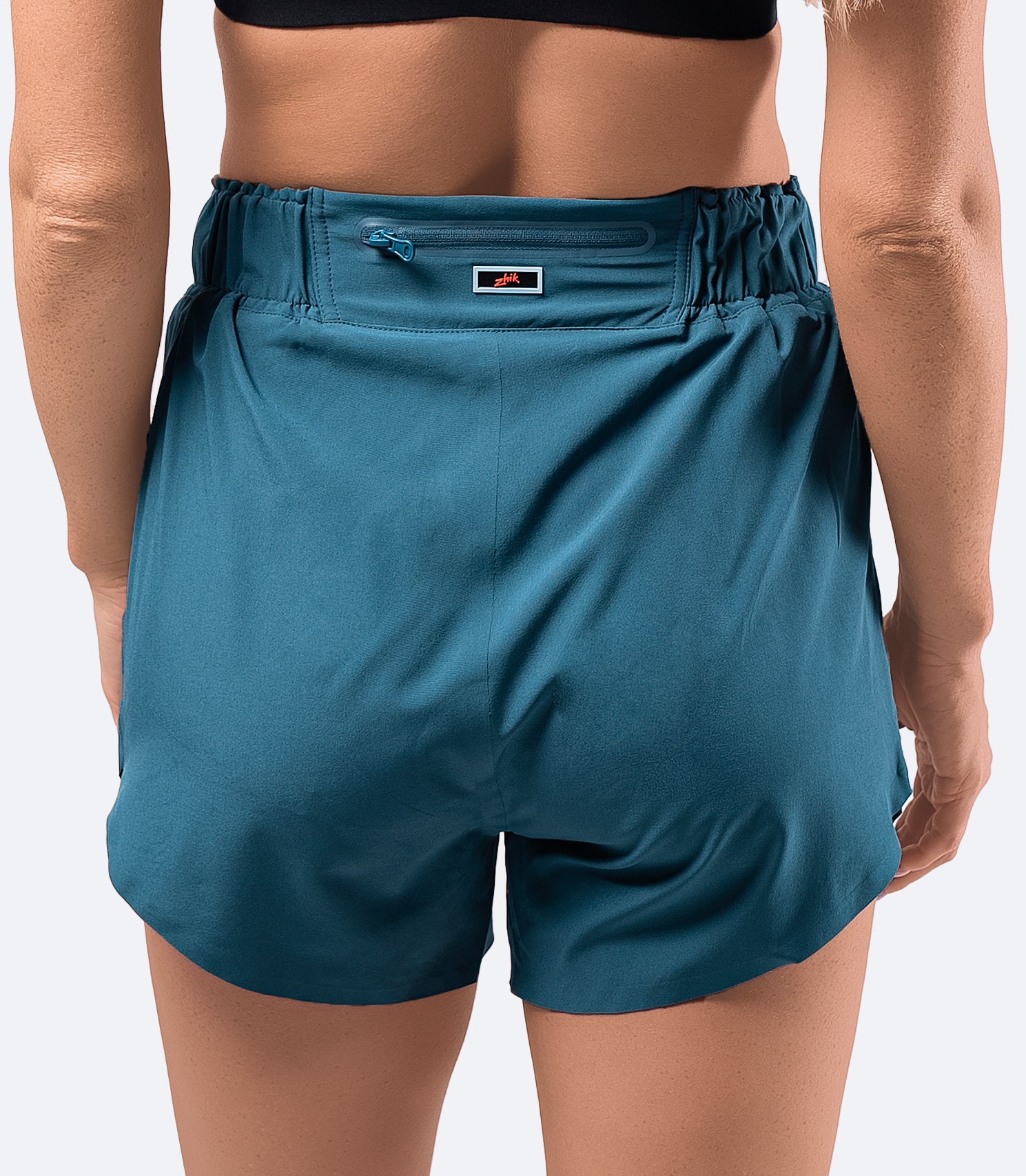 Back view of women's Provincial Blue board short – high-waisted with a discreet rear zippered pocket for small essentials.