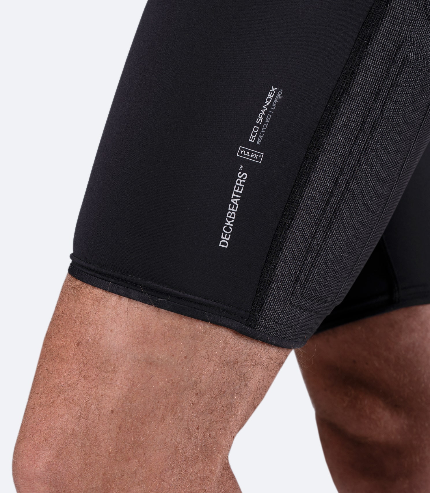 Close-up of Zhik DeckBeater X Short in Black showing thigh branding and Yulex logo on recycled stretch fabric
