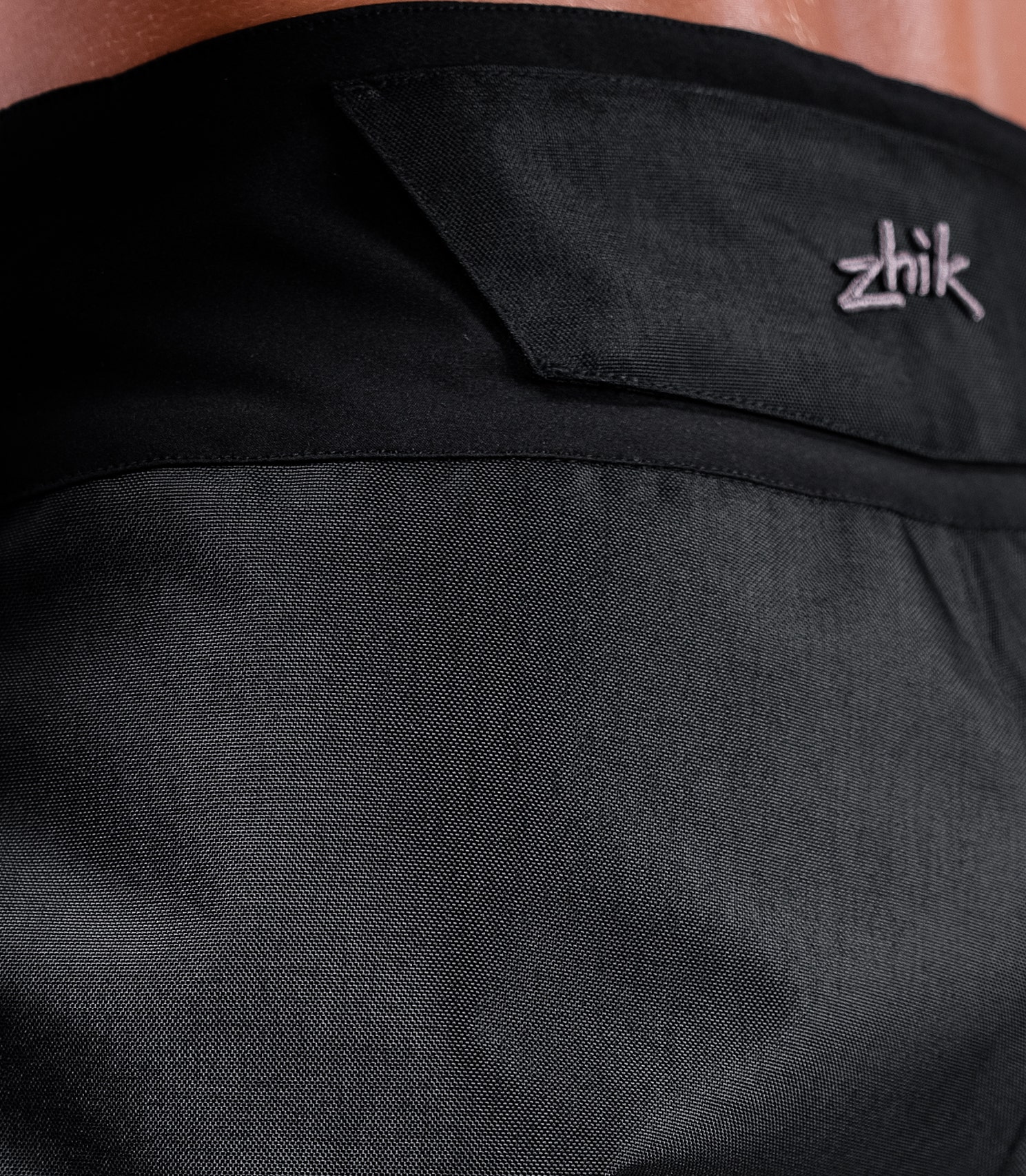 Close-up rear waistline of Zhik INS200™ Waterproof Shorts in black, highlighting pre-shaped waistband and oversized belt loops.