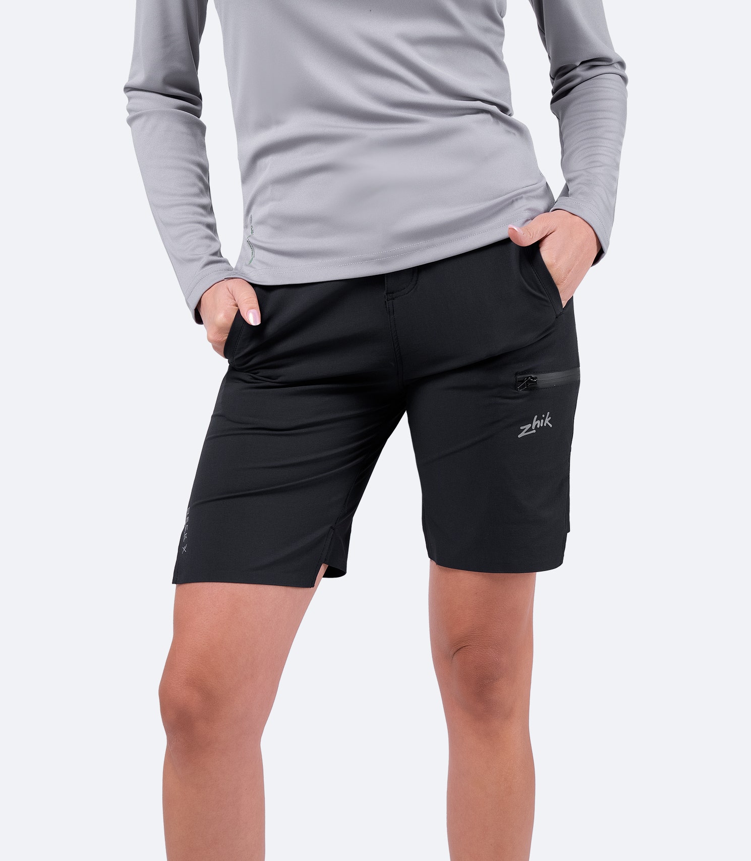 Front view of Zhik Women's Black Deck Shorts in a casual look, featuring hands in pocket and a relaxed, versatile fit for everyday wear