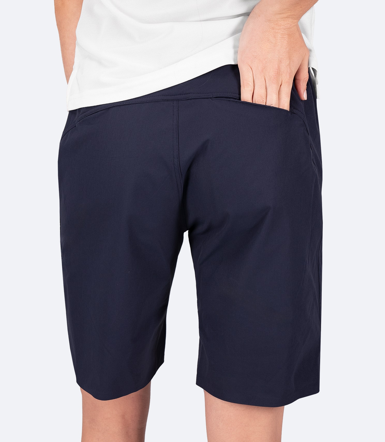 Rear view of Zhik Women's Navy Deck Shorts with hand in back pocket, showcasing sleek design and secure storage for essentials