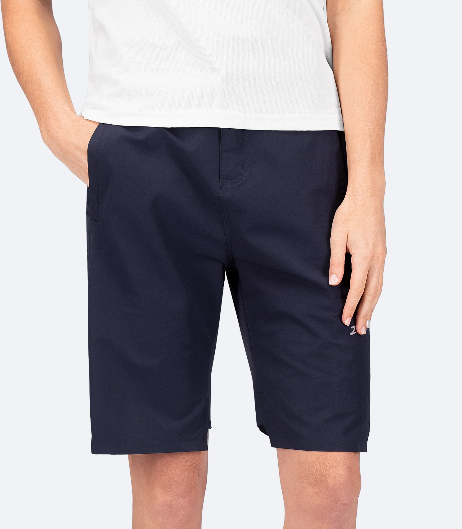 Front view of Zhik Women's Navy Deck Shorts in a casual look, featuring one hand in pocket and a relaxed, versatile fit for everyday wear