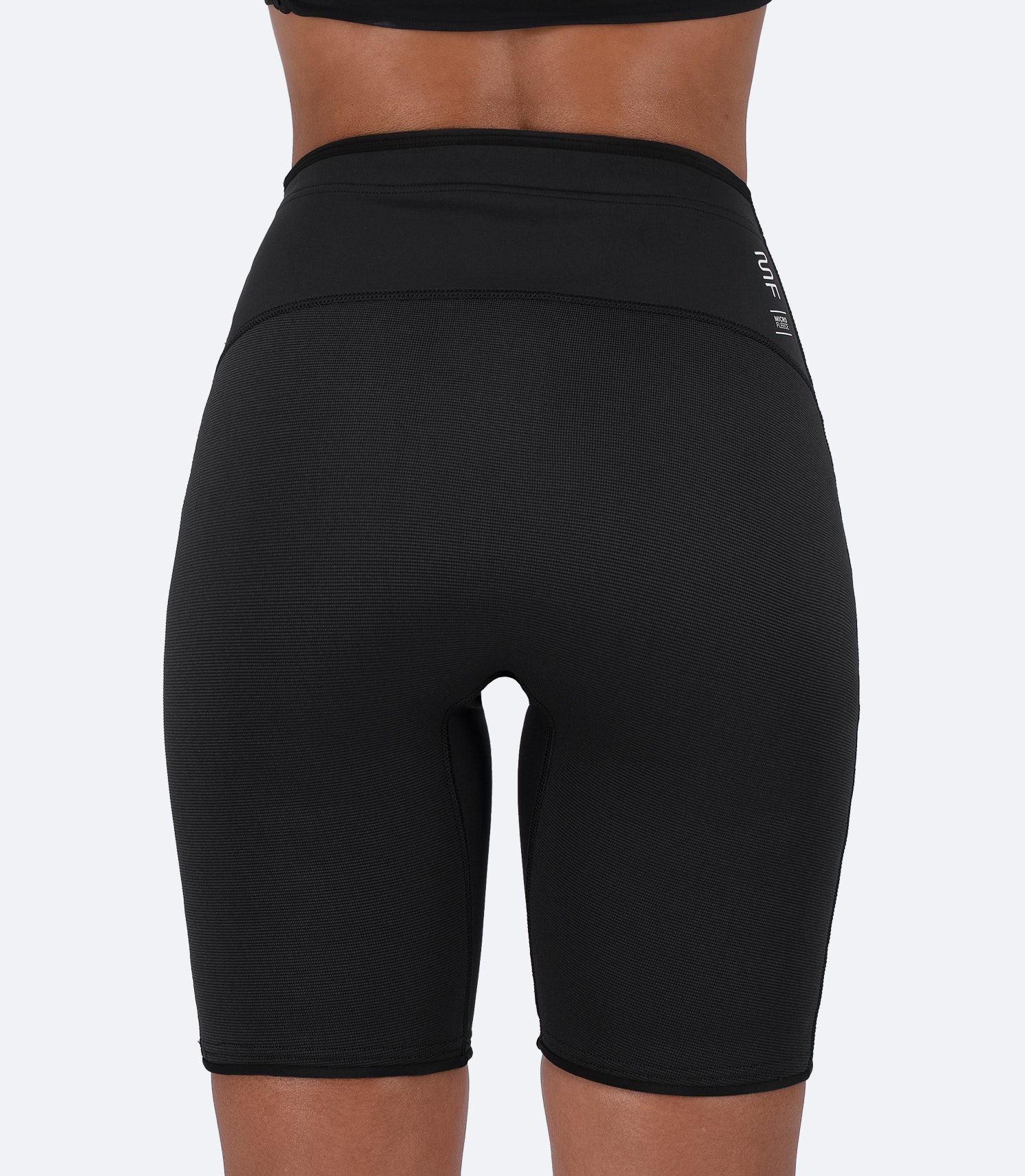 Rear close-up of black Zhik Microfleece™ Performance Shorts on female model, highlighting ZhikTex™ II abrasion-resistant seat.
