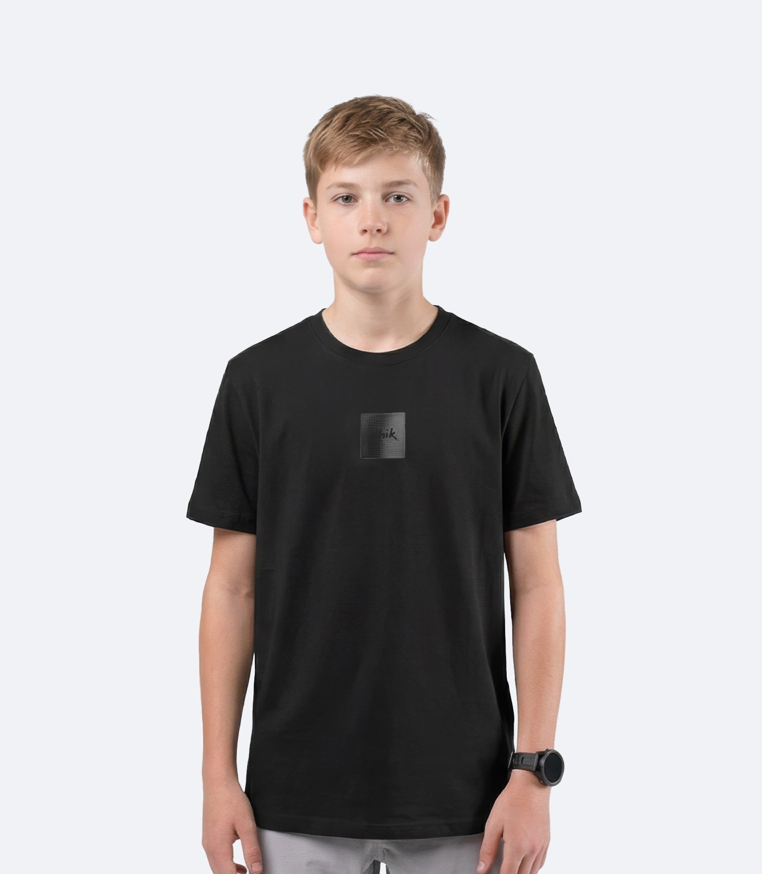 Zhik youth Carbon T Shirt in Black on male model front view, showing subtle textured Carbon logo branding on chest