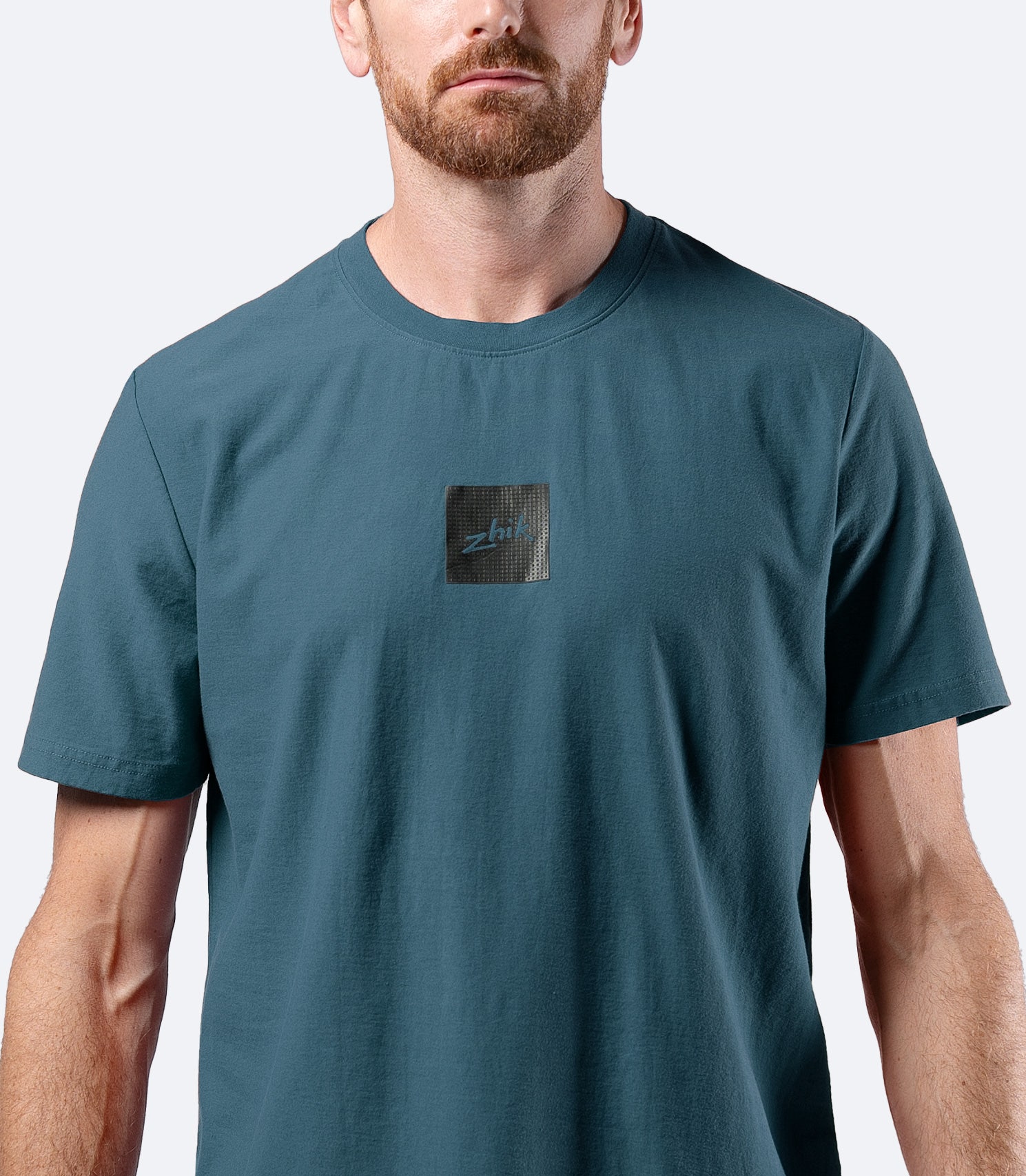 Close-up of Zhik logo on chest of Men's Carbon T-shirt in Deep Teal, showing premium cotton texture