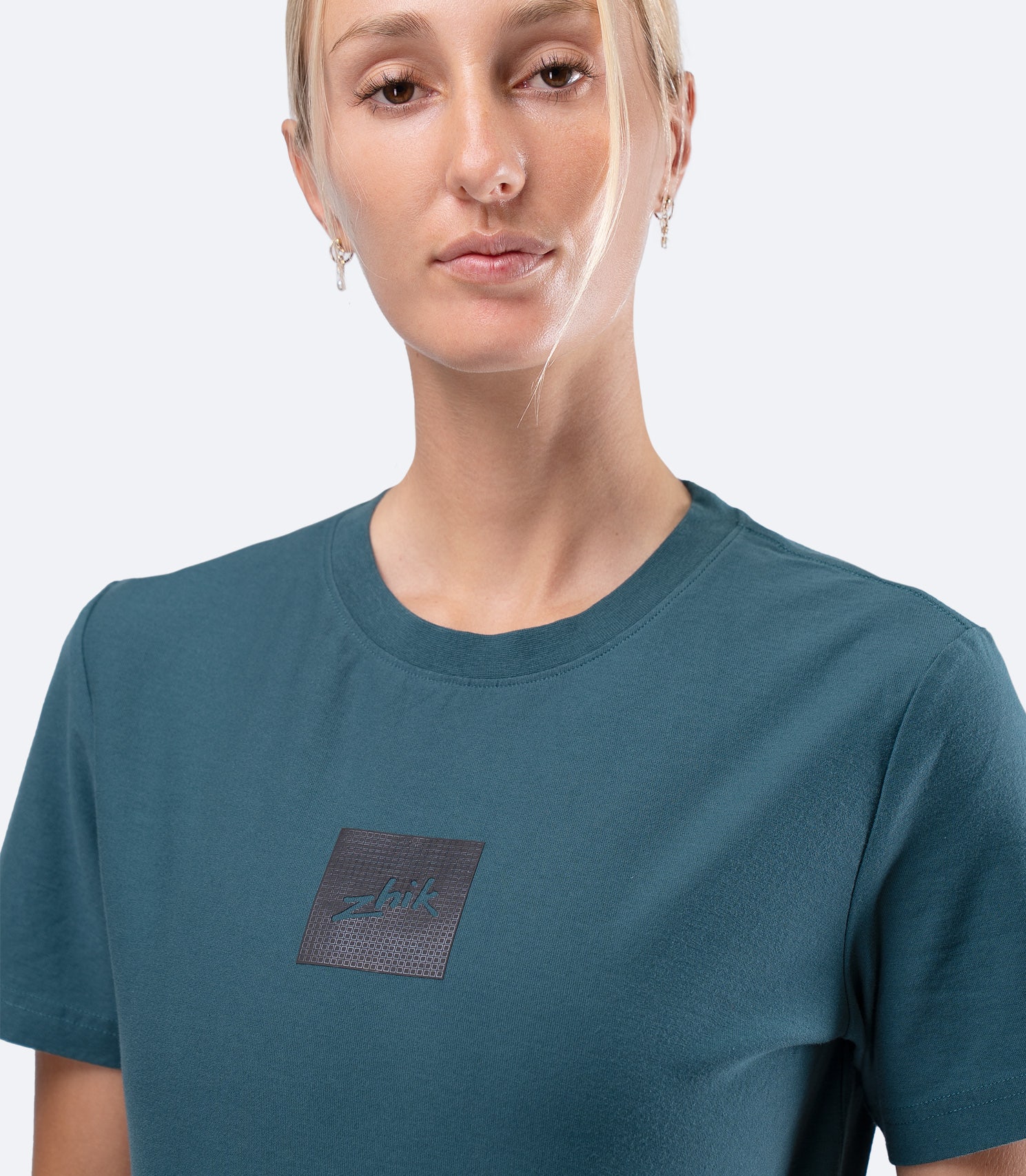 Zhik Womens Carbon T-Shirt in Deep Teal, close-up of upper chest showing subtle textured Carbon logo