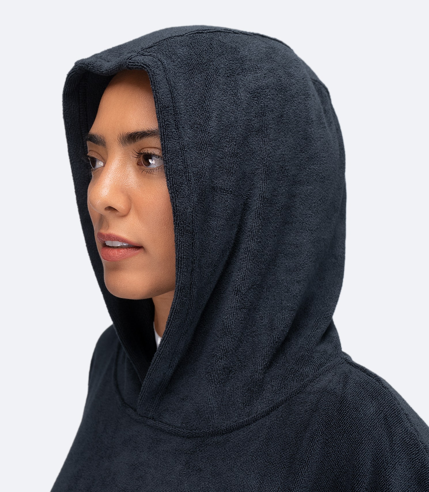 Close-up side view of Zhik Hooded Towel in Dark Blue on female model, showing fitted hood for warmth and comfort.