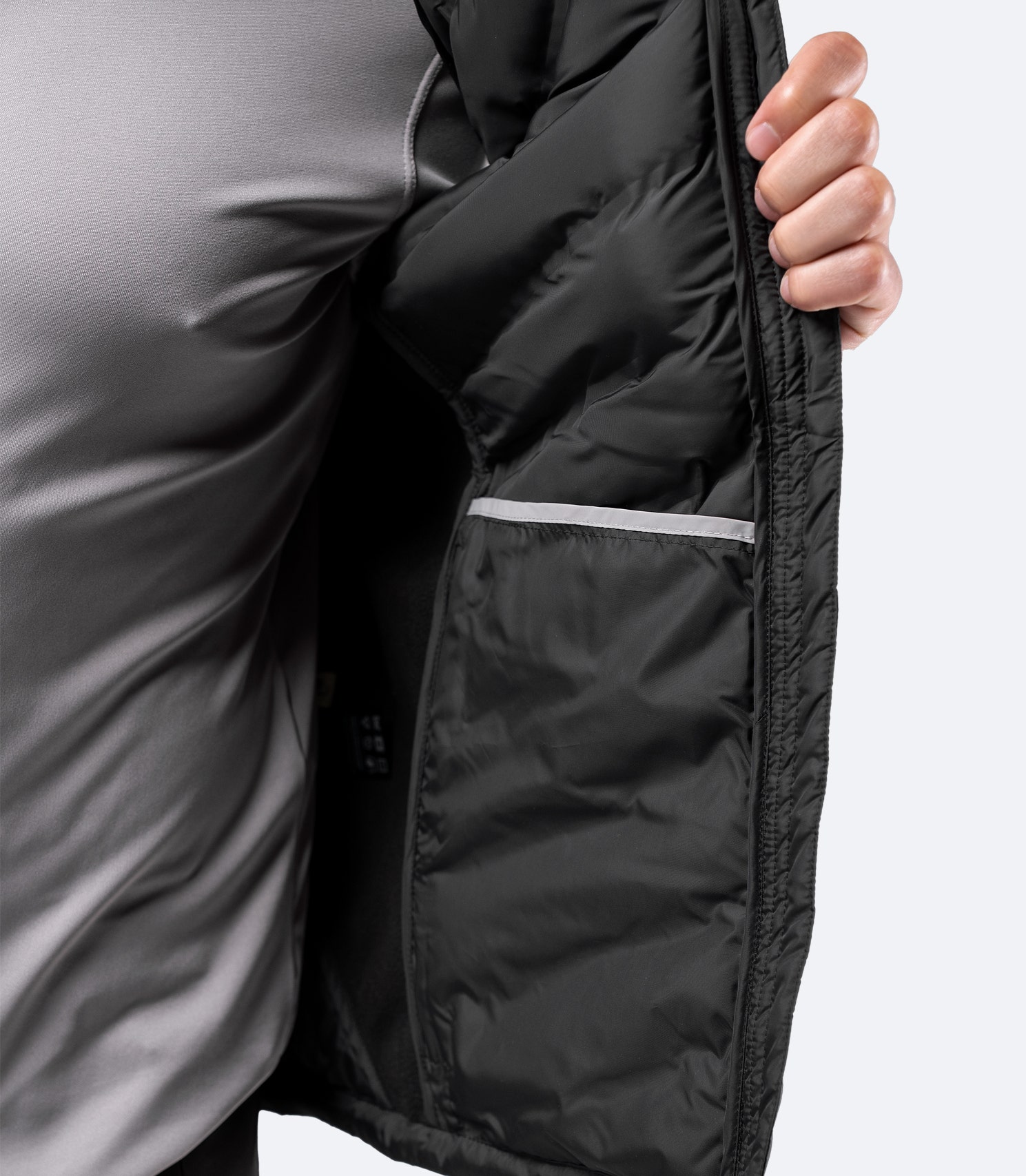 Close-up of Black Cell Vest internal stash pocket – spacious design for beanies, gloves, or accessories.