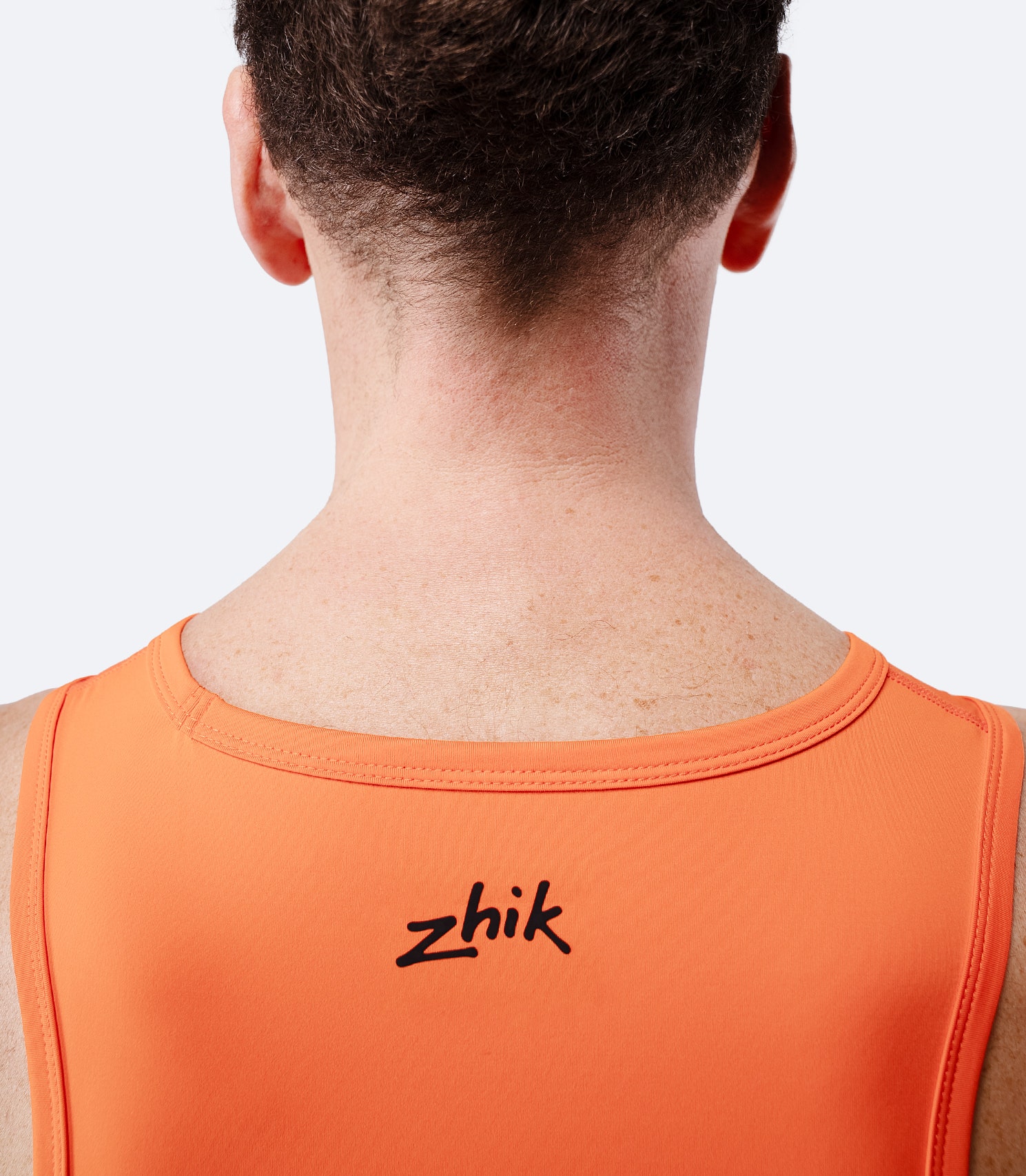 Zhik Men's Eco Spandex LT Race Singlet in flame red, close-up of back neckline with printed Zhik branding.