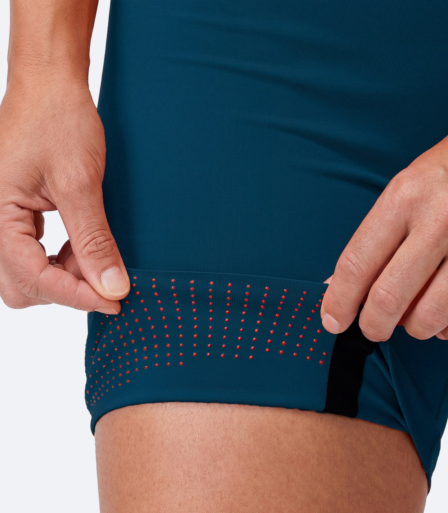 Zhik Women's X Unisuit in Deep Teal with folded thigh hem showing silicone grip zones and reduced seam design.