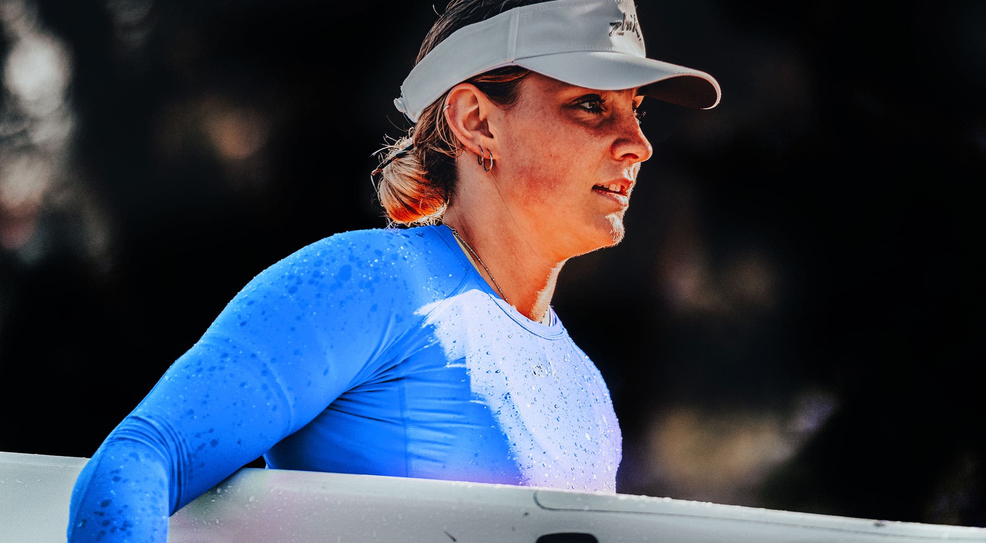 Paddle athlete launching their surf ski at the beach wearing Zhik performance paddling gear.